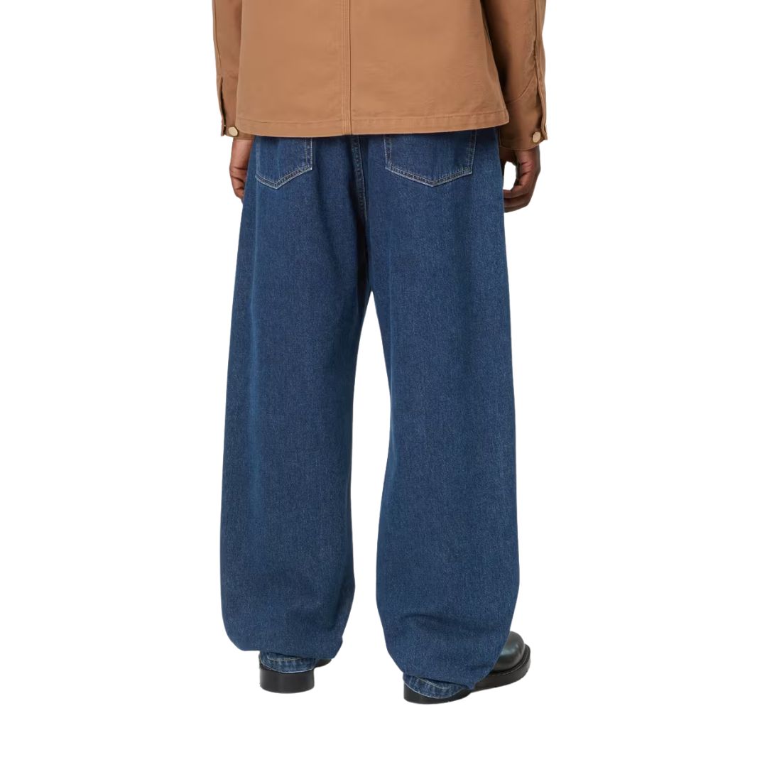 Pantalón vaquero Carhartt WIP Landon azul stone washed, primer plano trasero en modelo mostrando los bolsillos traseros y el estrechamiento bajo la rodilla.
