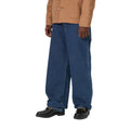 Pantalón vaquero Carhartt WIP Landon azul stone washed, primer plano lateral en modelo mostrando la caída del tejido denim y el ancho en el muslo.