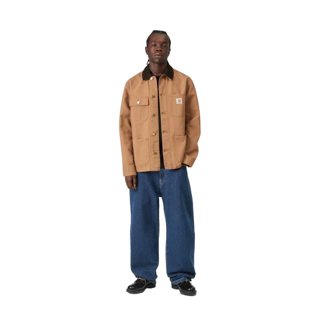 Pantalón vaquero Carhartt WIP Landon azul stone washed puesto por un modelo con chaqueta camel, mostrando el ajuste loose tapered de cintura a tobillo.