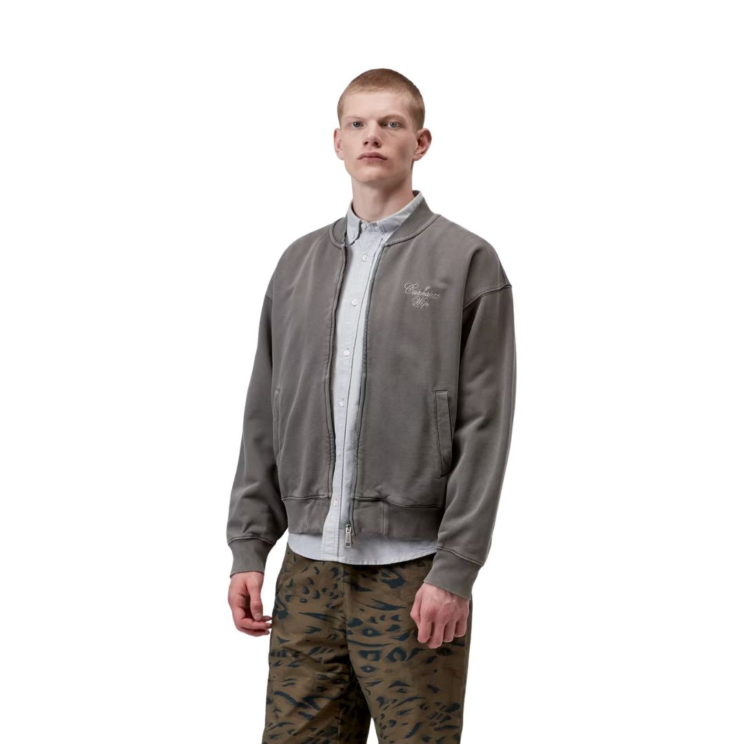 Hombre con chaqueta bomber Carhartt WIP gris garment dyed de corte amplio y estilo urbano.