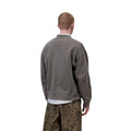 Vista trasera de chaqueta bomber Carhartt WIP gris garment dyed para hombre con cuello acanalado y corte relaxed fit.