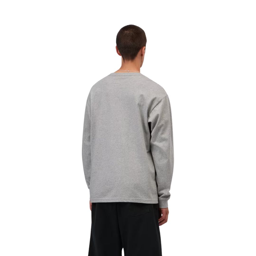 Camiseta de manga larga Carhartt WIP Chase gris jaspeado puesta por un modelo, vista trasera, combinada con pantalón negro, mostrando el corte oversize de espalda.