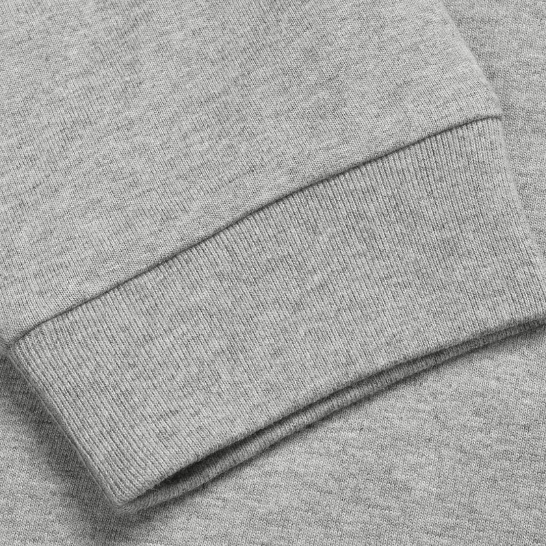 Camiseta de manga larga Carhartt WIP Chase en gris jaspeado (grey heather), primer plano del puño acanalado mostrando la textura del tejido de punto de algodón.