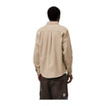 Vista trasera de modelo con la camisa de pana Carhartt WIP L/S Madison Cord Shirt en color Wall, beige claro con espalda de pana, sobre fondo blanco liso.