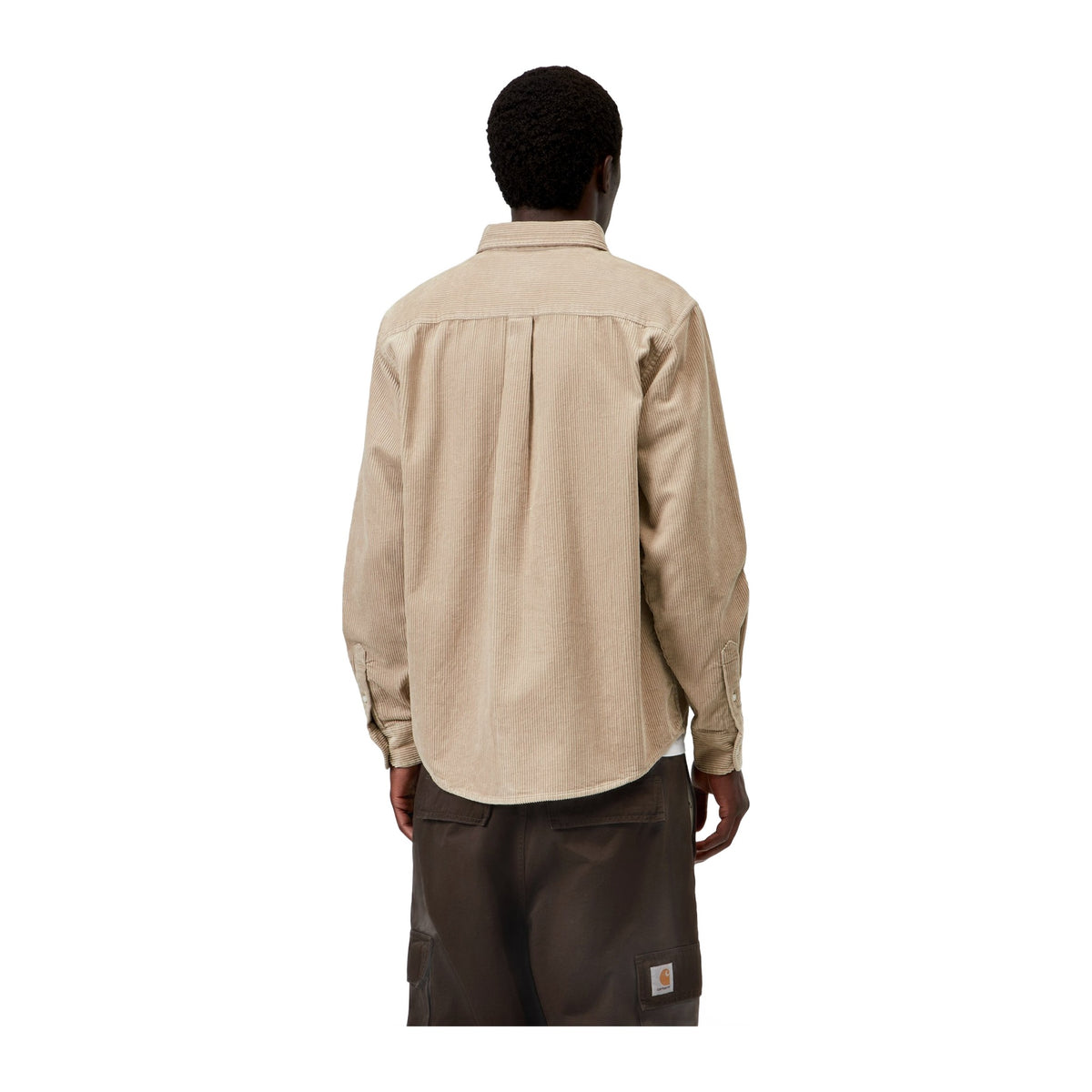 Vista trasera de modelo con la camisa de pana Carhartt WIP L/S Madison Cord Shirt en color Wall, beige claro con espalda de pana, sobre fondo blanco liso.