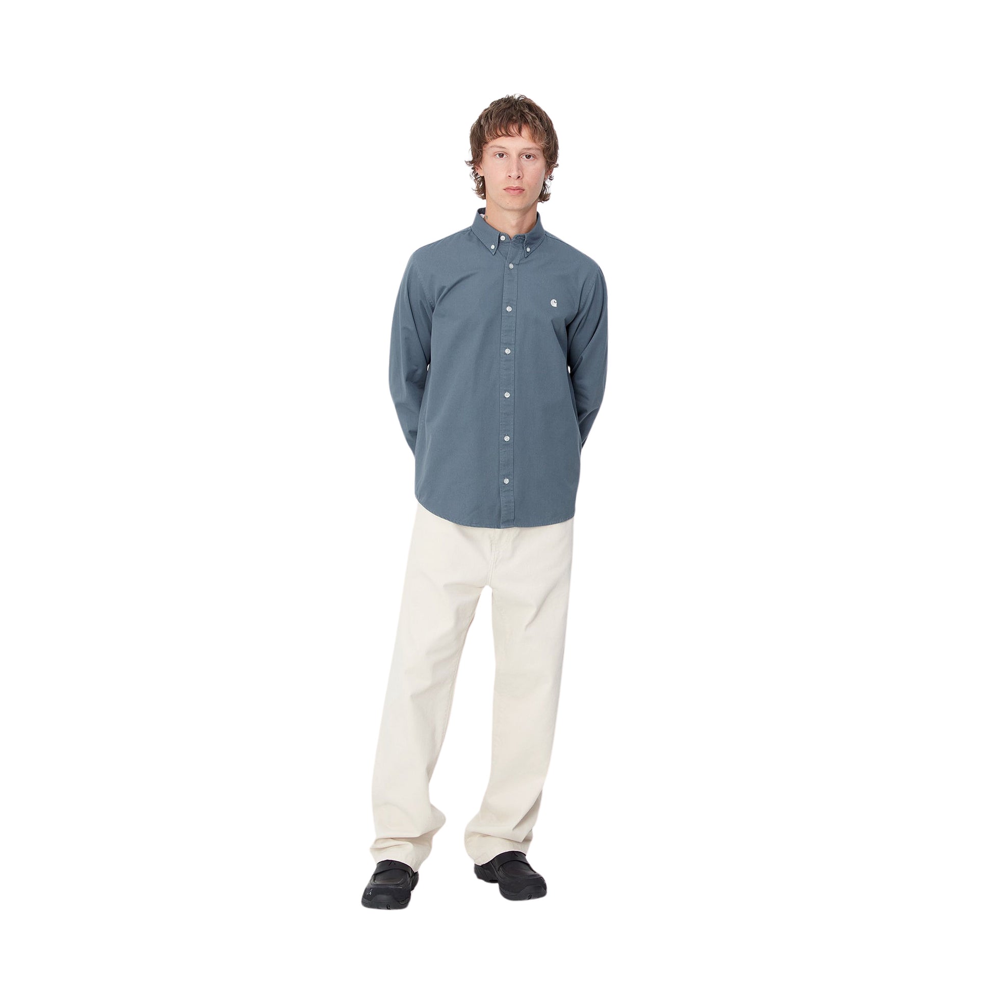 Hombre con la camisa de franela Carhartt WIP L/S Madison Shirt Positano y pantalón blanco