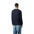 Vista trasera de modelo con camiseta carhartt wip l/s pocket t-shirt azul marino oscuro y pantalón vaquero.