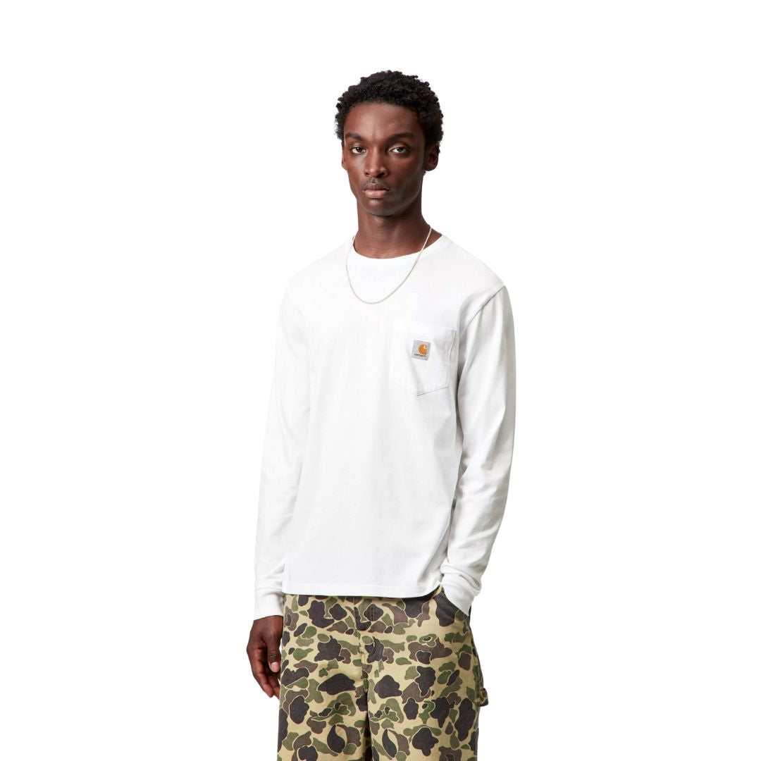 Plano medio de modelo con camiseta carhartt wip l/s pocket t-shirt blanca y bolsillo en el pecho.