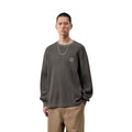 Modelo luce de frente la Carhartt WIP L/S Vista Waffle T-Shirt en negro, primer plano del torso. Se distingue con detalle la etiqueta cuadrada tejida y la textura de panal del algodón.