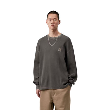 Modelo luce de frente la Carhartt WIP L/S Vista Waffle T-Shirt en negro, primer plano del torso. Se distingue con detalle la etiqueta cuadrada tejida y la textura de panal del algodón.
