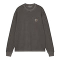 Carhartt WIP L/S Vista Waffle T-Shirt en negro, vista frontal plana. Destaca la etiqueta cuadrada tejida Carhartt en el pecho y la textura gofrada del algodón teñido en prenda.