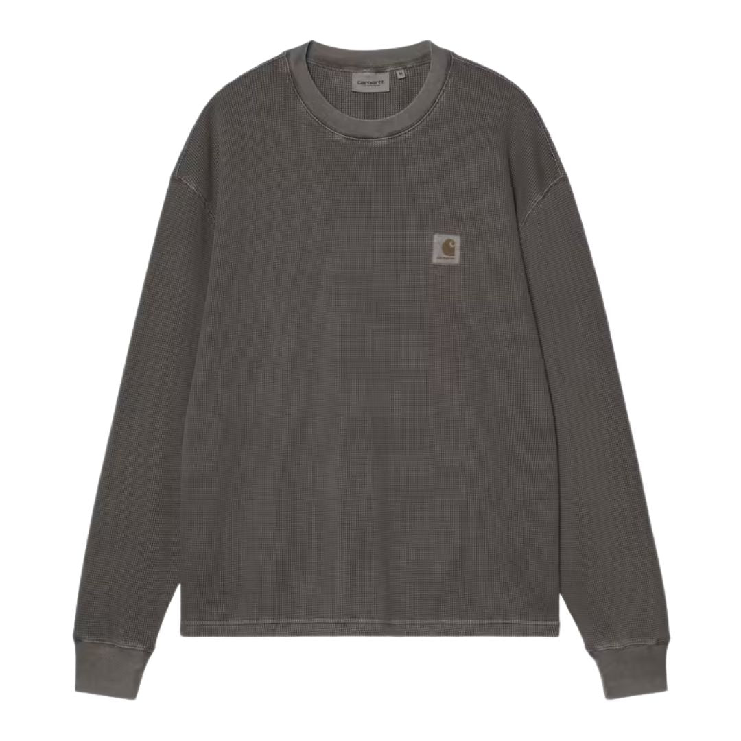 Carhartt WIP L/S Vista Waffle T-Shirt en negro, vista frontal plana. Destaca la etiqueta cuadrada tejida Carhartt en el pecho y la textura gofrada del algodón teñido en prenda.