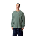 Modelo luce de frente la Carhartt WIP L/S Vista Waffle T-Shirt en verde dark scarab, primer plano del torso. Se distingue la etiqueta cuadrada tejida y la textura de panal del algodón.