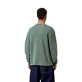 Modelo con Carhartt WIP L/S Vista Waffle T-Shirt en verde dark scarab, vista trasera. Se aprecia la caída holgada del tejido gofrado sobre vaquero azul oscuro.