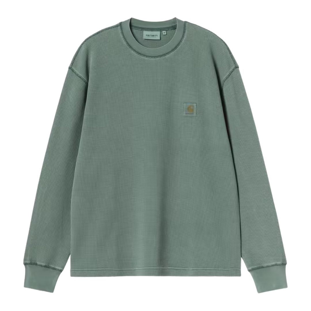 Carhartt WIP L/S Vista Waffle T-Shirt en verde dark scarab, vista frontal plana. Destaca la etiqueta cuadrada tejida Carhartt en el pecho sobre el tono verde teñido en prenda.