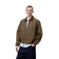 Carhartt WIP Madison Ripstop Jacket en Dark Beech y negro garment dyed, vista frontal plana con cremallera central, bolsillos ribeteados y cuello de pana en tono oscuro contrastado.