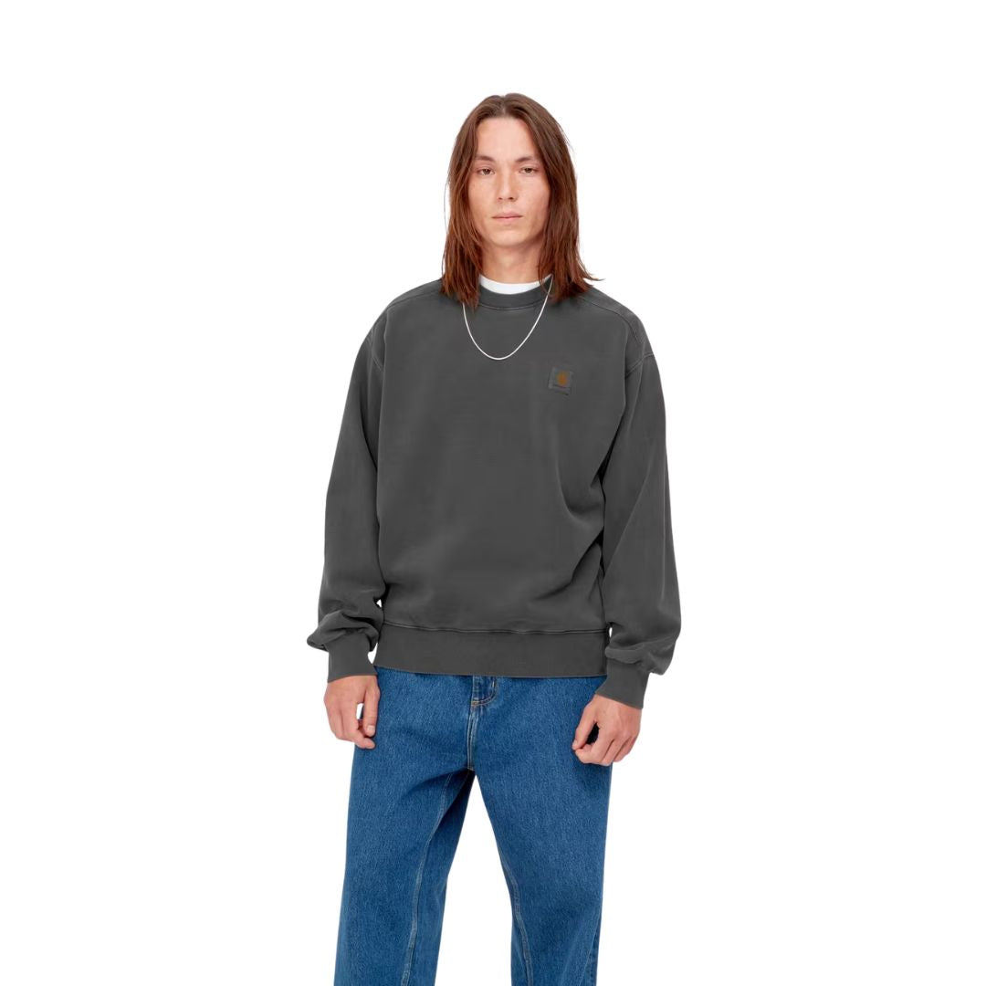 Carhartt WIP Nelson Sweatshirt Black Garment Dyed vista frontal con modelo sudadera cuello redondo algodón pesado etiqueta cuadrada.