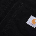 Vista frontal superior del pantalón de pana Carhartt WIP Newel Cord Pant color negro mostrando cinturilla y bolsillos.