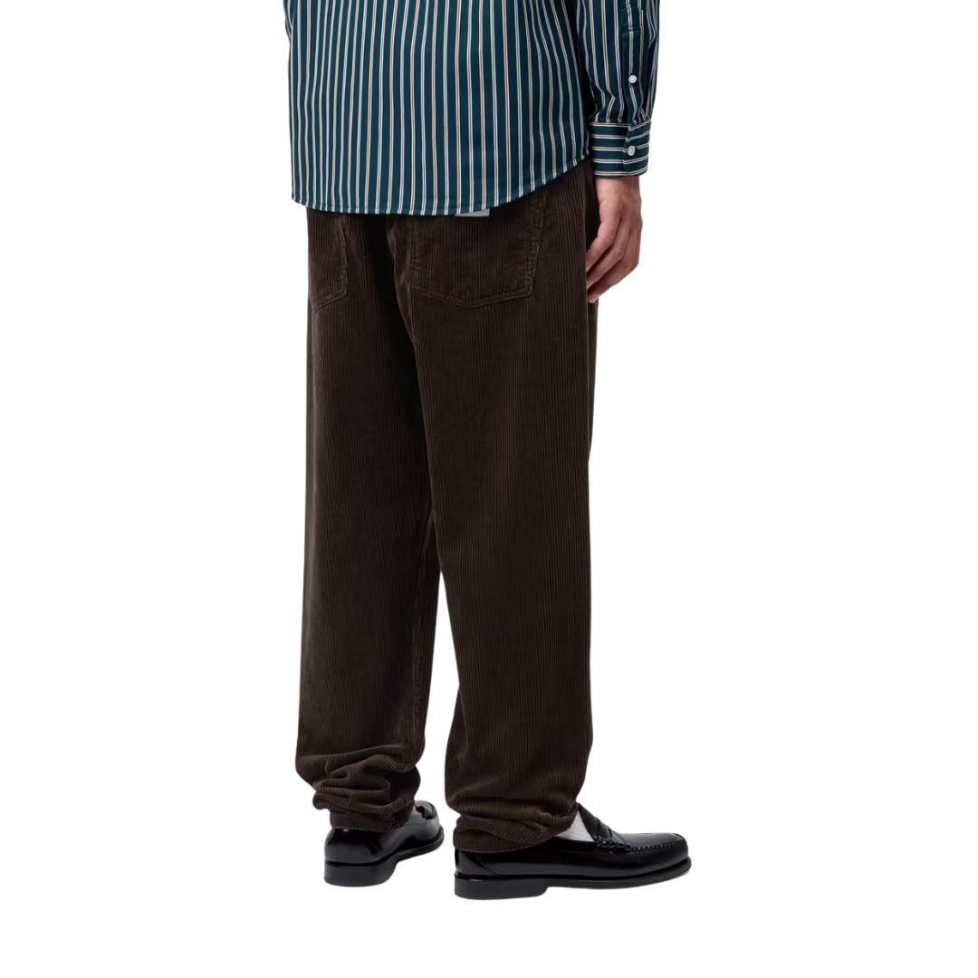 Vista trasera del modelo llevando el pantalón de pana Carhartt WIP Newel Cord Pant color marrón tobacco.