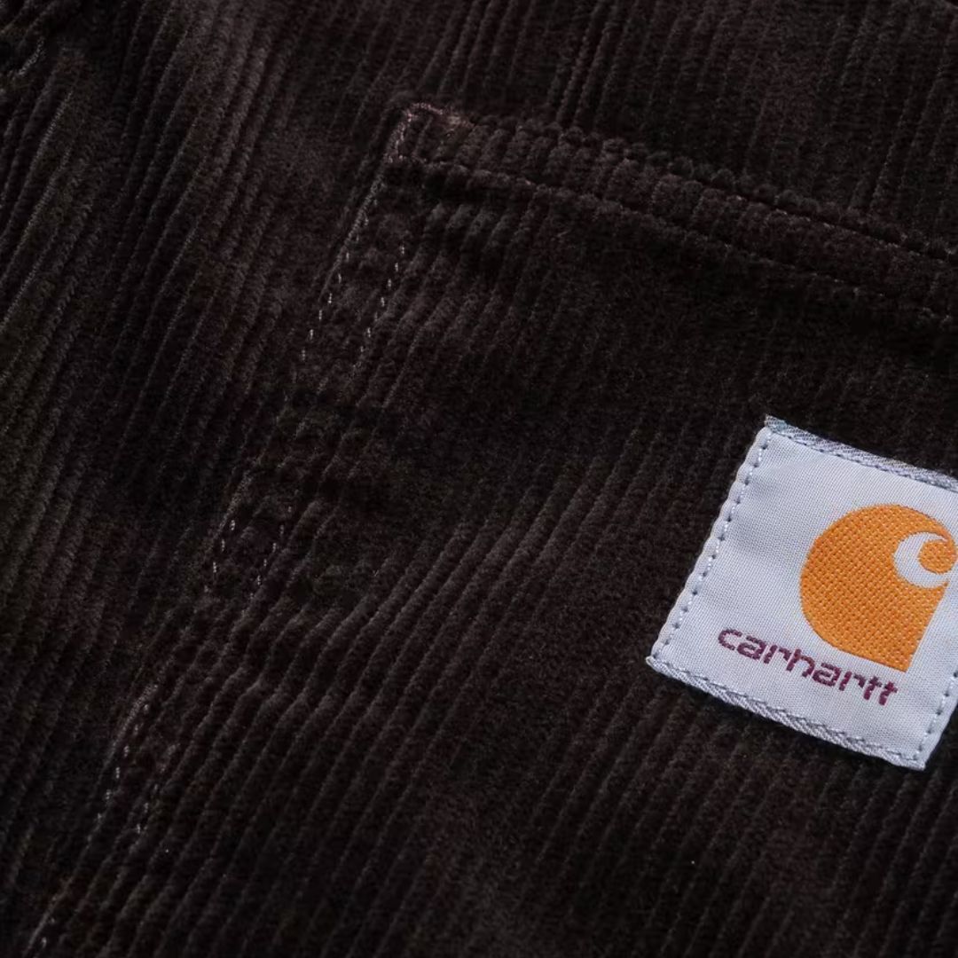 Vista frontal completa del pantalón de pana Carhartt WIP Newel Cord Pant color marrón tobacco en plano neutro.