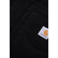 Detalle del bolsillo trasero derecho del pantalón de pana Carhartt WIP Newel Pant en color negro, con la etiqueta Square Label tejida y el canalé ancho de la pana Coventry en primer plano.