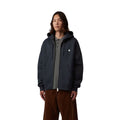 Modelo con la Carhartt WIP Hooded Mack Sweat Jacket en color dark navy wax con la cremallera abierta sobre un polo, cordones de capucha colgando y logo C bordado en el pecho, plano frontal.