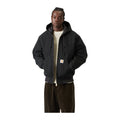 Modelo de frente con la chaqueta de lona con capucha Carhartt WIP OG Active Jacket en color Black, con cremallera, bolsillo canguro y etiqueta cuadrada en el bajo.