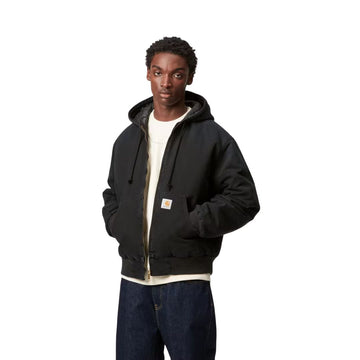 Modelo vistiendo la chaqueta Carhartt WIP OG Active Jacket negra de frente con capucha y cremallera abierta.