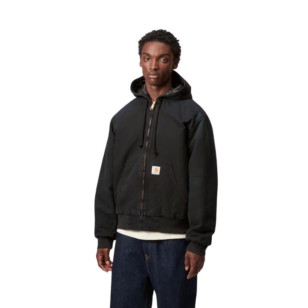 Modelo vistiendo la chaqueta Carhartt WIP OG Active Jacket negra de frente con capucha y cremallera cerrada.