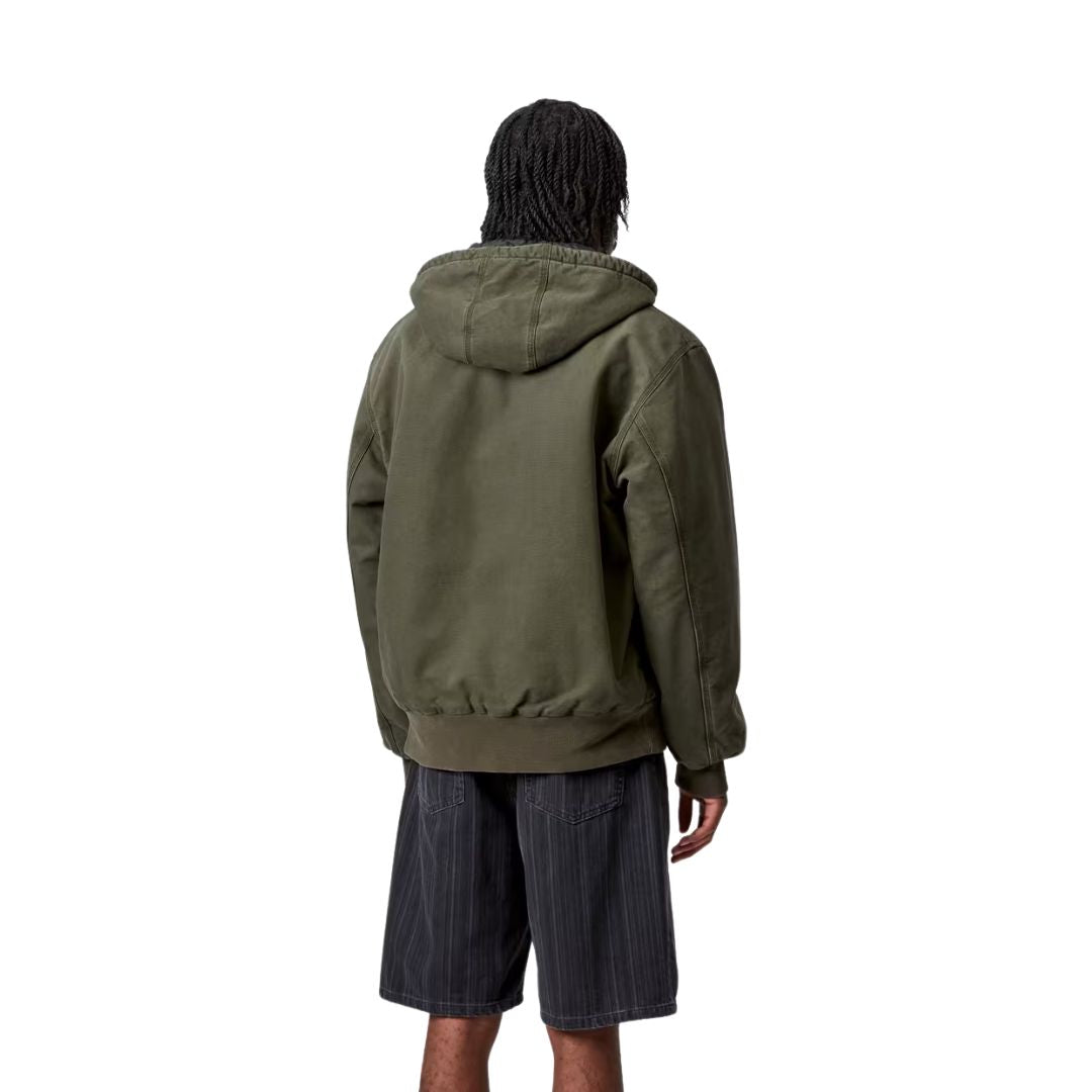 Modelo vistiendo la chaqueta Carhartt WIP OG Active Jacket color oliva de espaldas mostrando la capucha.