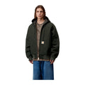 Modelo de frente con la chaqueta de lona con capucha Carhartt WIP OG Active Jacket en color Raven, verde muy oscuro con cremallera y bolsillo canguro.