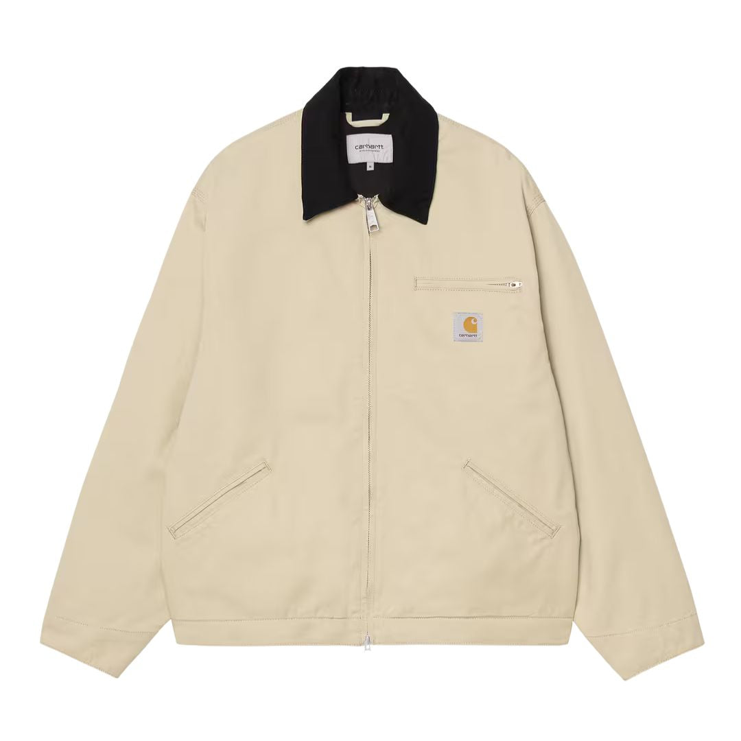 Carhartt WIP OG Detroit Jacket Barchan Black Rinsed vista frontal, chaqueta de canvas beige con cuello de pana negro, cremallera bidireccional, bolsillo con cremallera en el pecho, bolsillos de ojal y etiqueta Carhartt WIP.