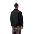 Vista trasera del modelo con la Carhartt WIP OG Detroit Jacket Winter en color negro, mostrando los hombros caídos, el cuello de pana y la banda inferior ajustable a presión.