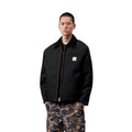 Vista frontal del modelo con la Carhartt WIP OG Detroit Jacket Winter en color negro, mostrando los hombros caídos, el cuello de pana y la banda inferior ajustable a presión