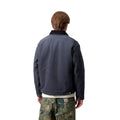 Carhartt WIP OG Detroit Jacket Winter color Dark Navy Black vista trasera en modelo, chaqueta canvas de invierno con ajuste holgado.
