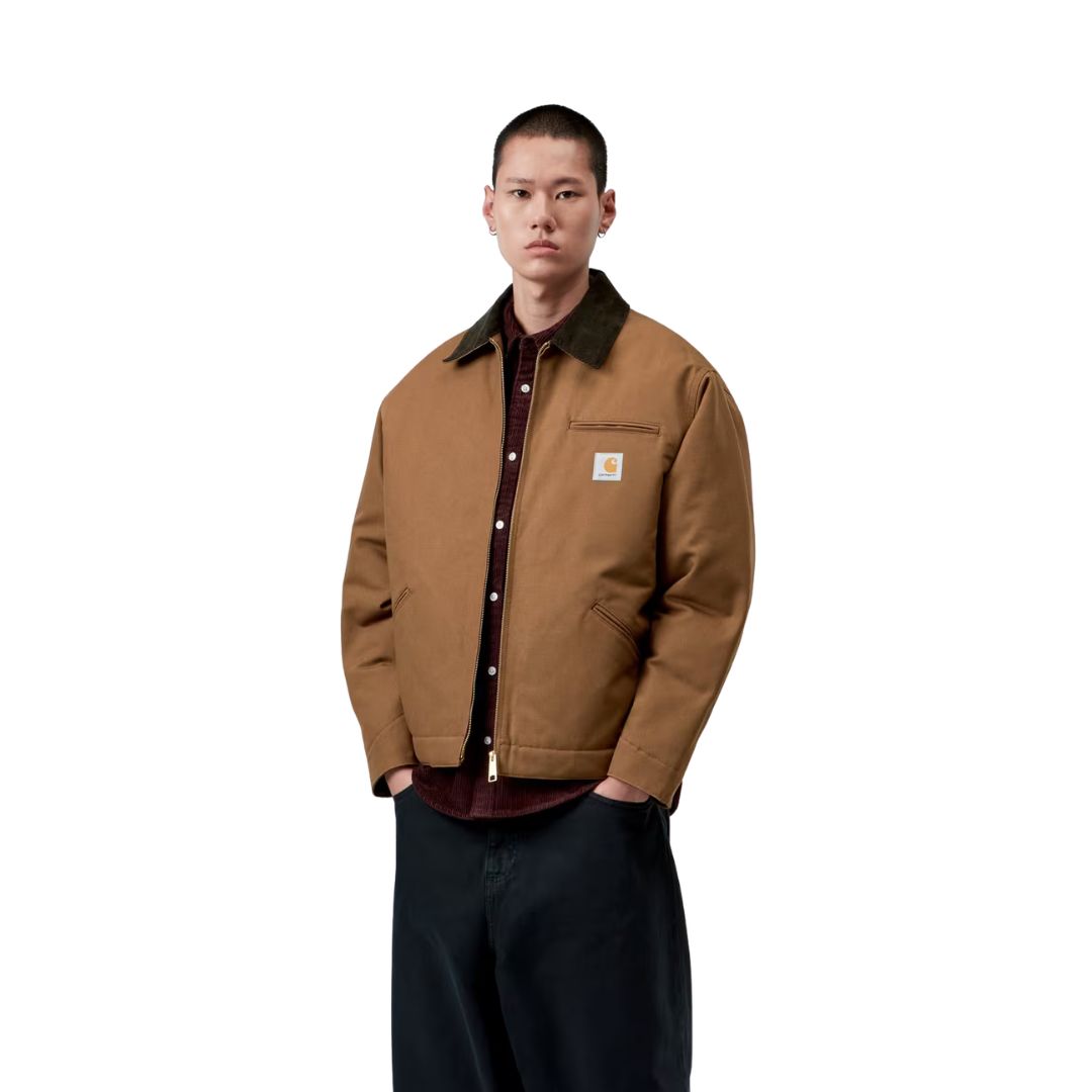 Vista frontal del modelo con la Carhartt WIP OG Detroit Jacket Winter en color marrón, mostrando los hombros caídos, el cuello de pana oscuro y la banda inferior ajustable.