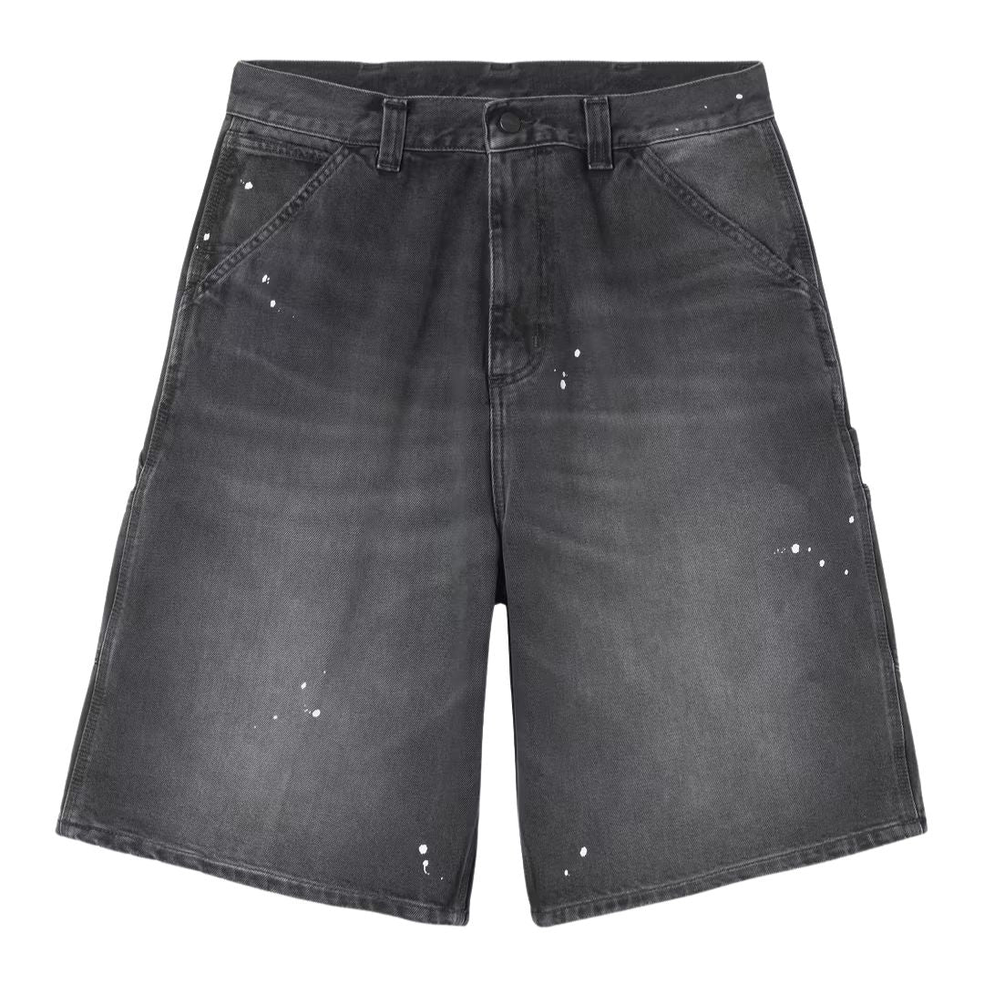 Carhartt WIP OG Single Knee Short negro destroy wash, vista frontal producto plano, degradado gris en muslos y toques de pintura blanca splatter sobre denim negro.
