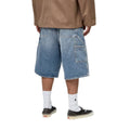 Carhartt WIP OG Single Knee Short azul destroy wash, vista trasera en modelo, bolsillos workwear grandes y toques de pintura blanca en denim desgastado.