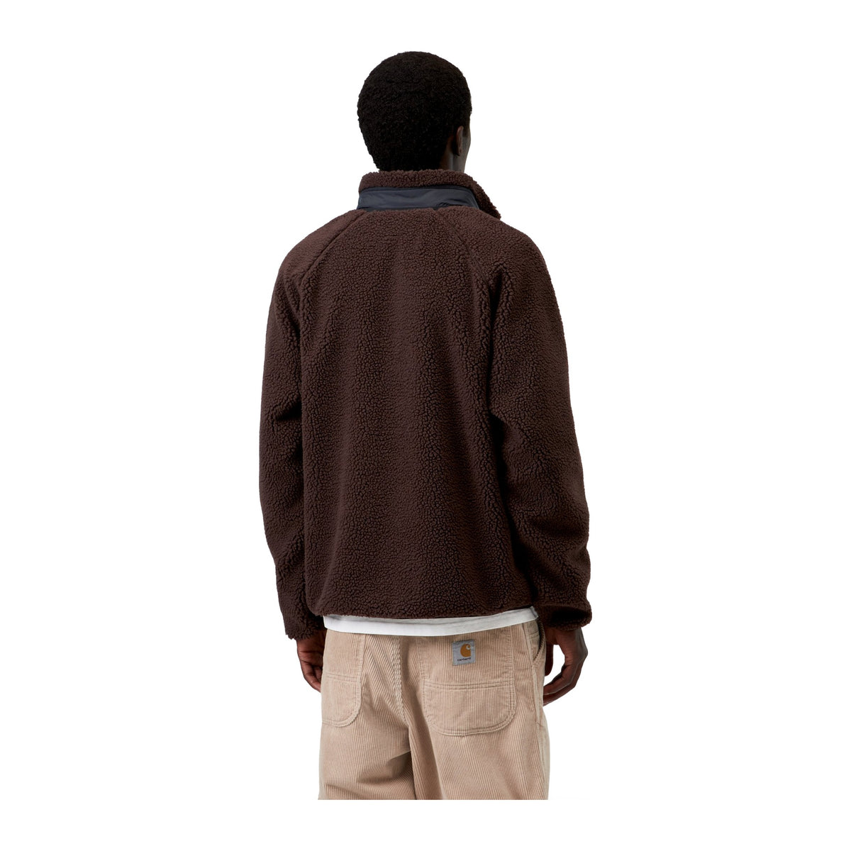 Vista trasera de modelo con la chaqueta forro polar Carhartt WIP Prentis Liner en color Palisander / Black, de pelo grueso marrón y con cuello alto, sobre fondo blanco liso.