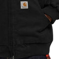 Detalle del bolsillo frontal y etiqueta Carhartt WIP en la Ravon Jacket color Black Heavy Stone Wash.