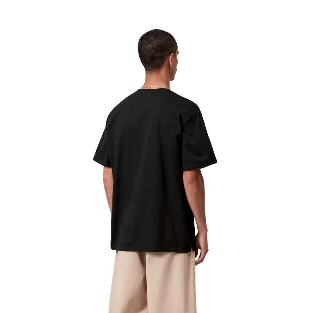 Carhartt WIP S/S Madison T-Shirt black/white, vista trasera sobre modelo con pantalón beige, mostrando la amplitud de espalda y el largo de las mangas cortas.