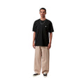 Carhartt WIP S/S Madison T-Shirt black/white combinada en look completo con pantalón ancho beige, mostrando el contraste del logo blanco y la caída loose fit.