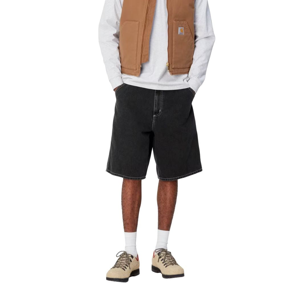 Pantalón corto Carhartt WIP Simple Short en denim negro black heavy stone wash, vista frontal en modelo.