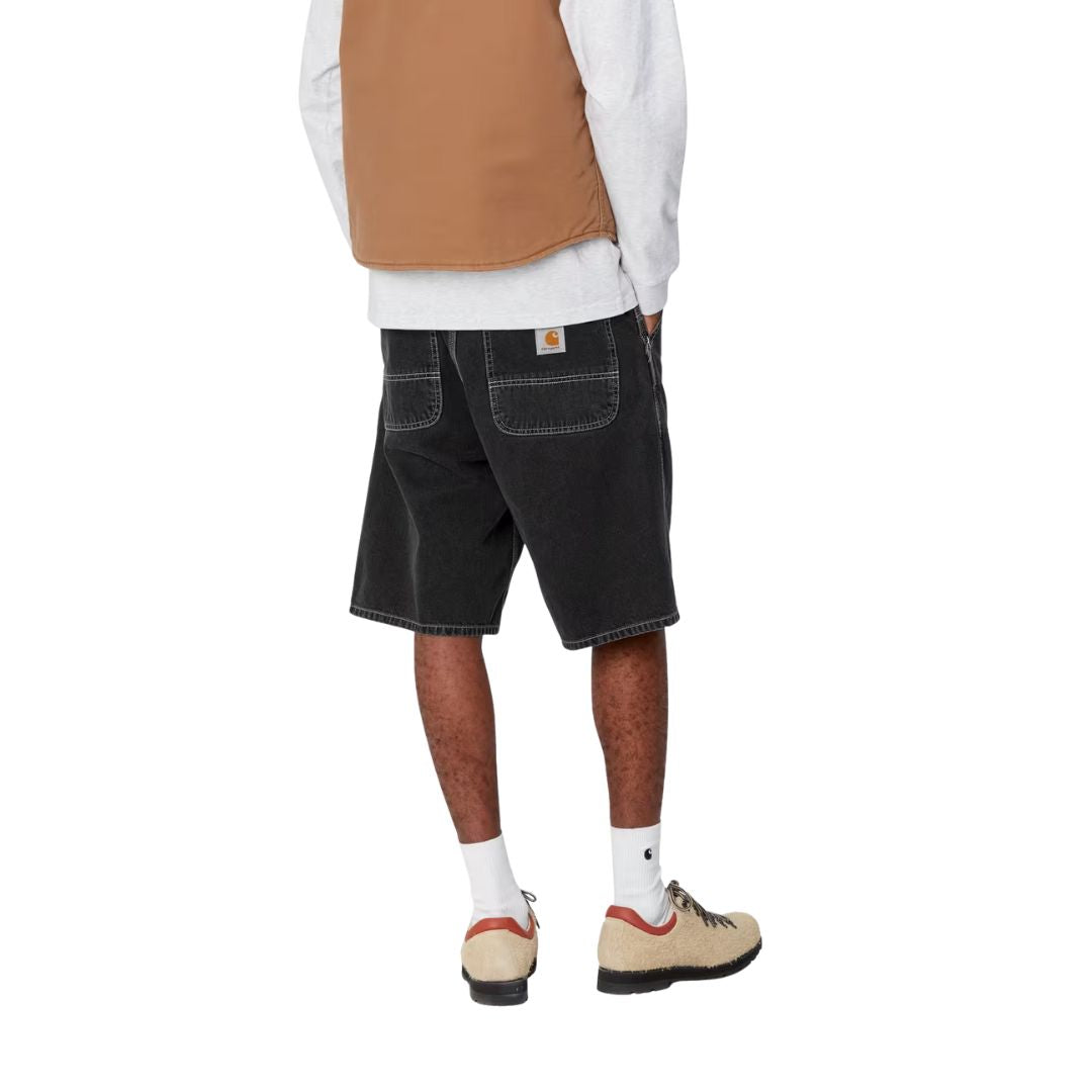 Pantalón corto Carhartt WIP Simple Short en denim negro black heavy stone wash, vista trasera en modelo.