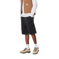Pantalón corto Carhartt WIP Simple Short en denim negro black heavy stone wash, vista lateral en modelo.