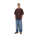 Modelo con pantalón Carhartt WIP Single Knee Pant en denim Blue Stone Washed combinado con camiseta oscura, mostrando el corte holgado y largo total de la prenda.