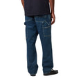 Vista trasera en modelo del pantalón Carhartt WIP Single Knee Pant en Blue Marble Used Wash, mostrando bolsillos traseros reforzados y el degradado del lavado marmoleado.