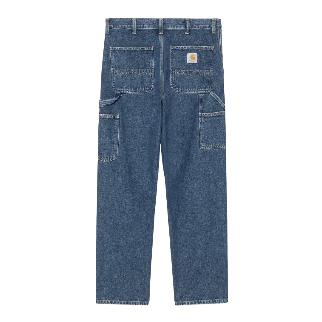 Vista trasera plana del pantalón Carhartt WIP Single Knee Pant en Blue Marble Used Wash, con parche de piel Carhartt, bolsillos traseros y efecto marmoleado en el desgaste.