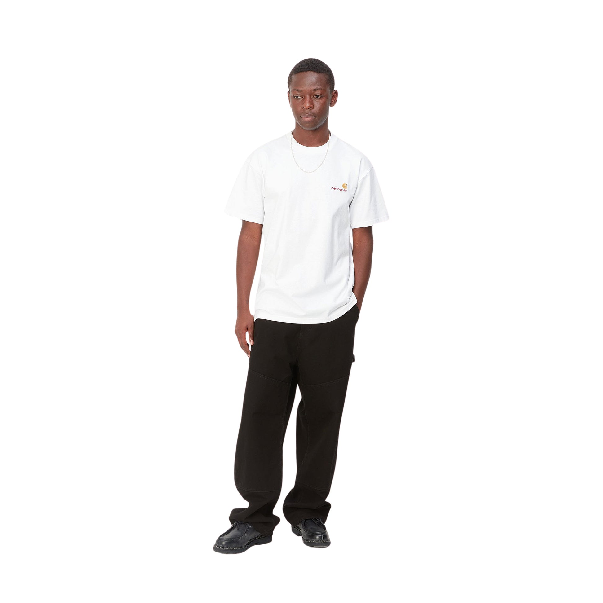 Hombre con la camiseta básica de manga corta Carhartt WIP S/S American Script T-Shirt Blanca y vaqueros negros