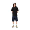 Modelo con el polo Carhartt WIP S/S Chase Pique negro con el logo bordado en dorado y shorts vaqueros